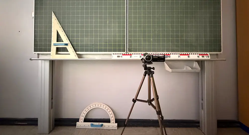 Foto eines Klassenraums mit einer Videokamera auf einem Stativ